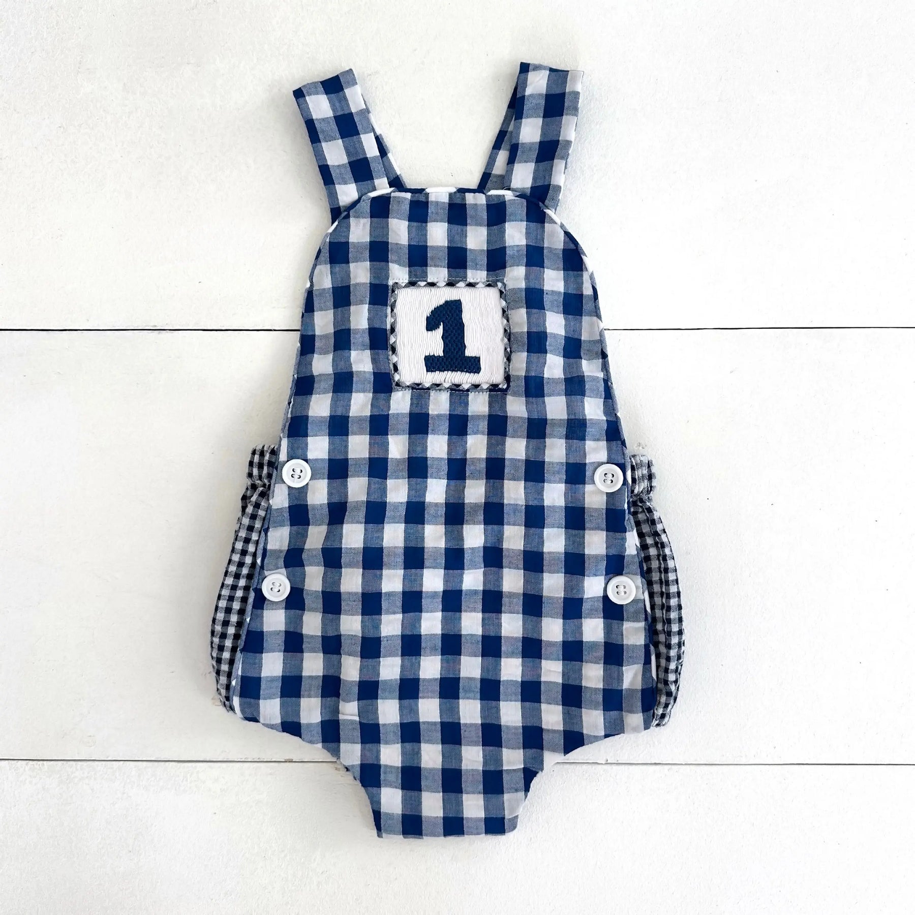 Navy Blue Smocked First Birthday Sunsuit by Seven Lantern Lane, children's boutique clothing main product photo