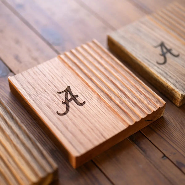 Oak phone and pen tray with the letter "A" engraved, made from wood sourced from the University of Alabama campus.