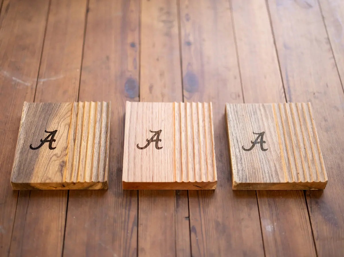 OAK PHONE AND PEN TRAY | UNIVERSITY OF ALABAMA: Three wooden phone and pen trays sit on a wooden surface.