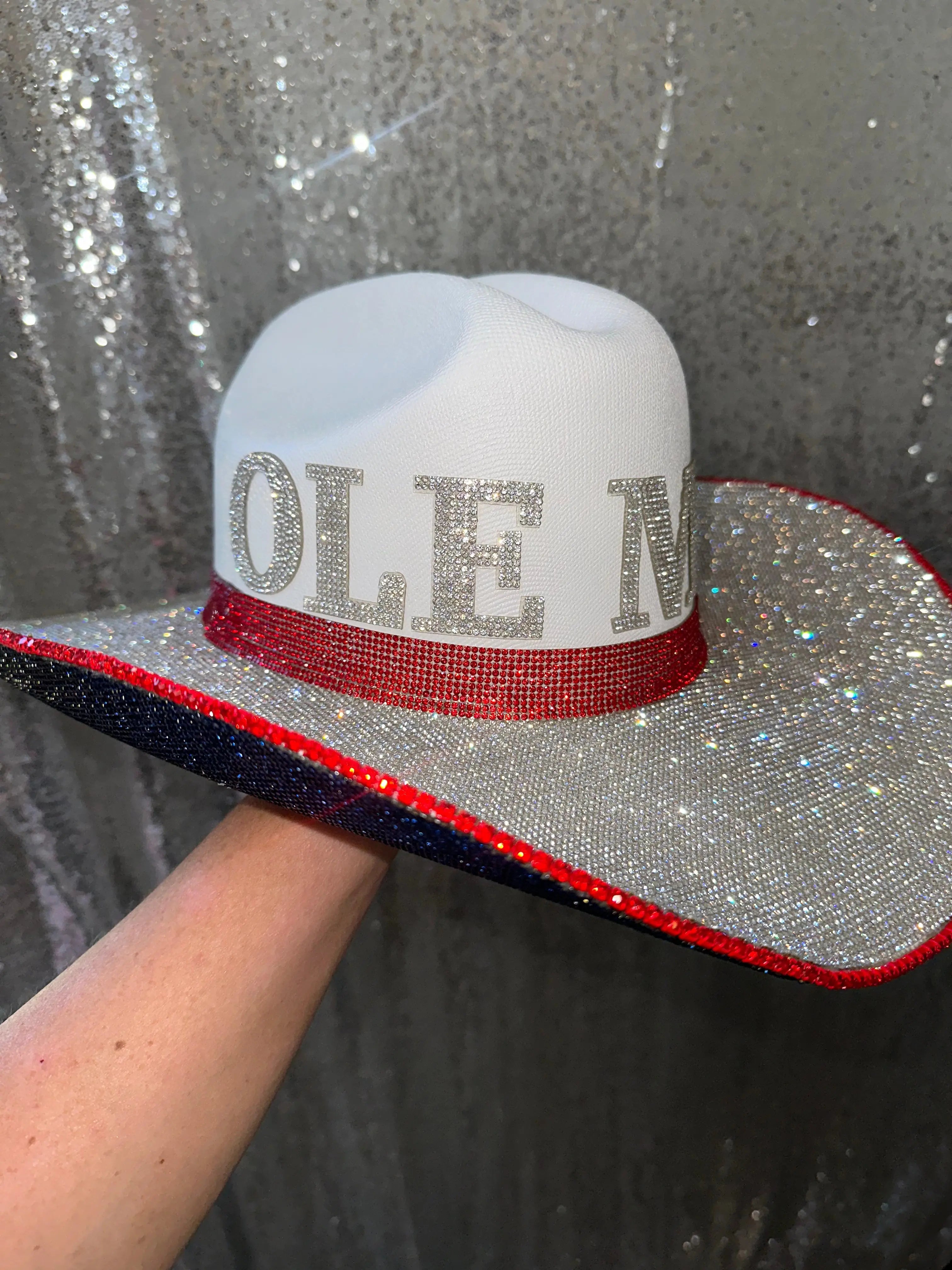 White cowboy hat with "OLE MISS" spelled out in rhinestones and red and blue trim.