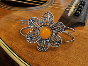 Decorative bracelet with a yellow center on a wooden surface
