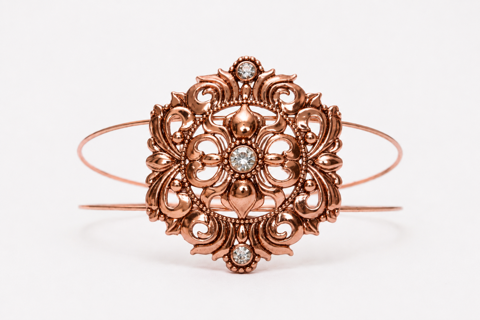 Rose gold bracelet with intricate design and diamond accents on a white background