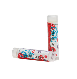 Two lip balms with a peppermint and bicycle design, one standing and one lying down.