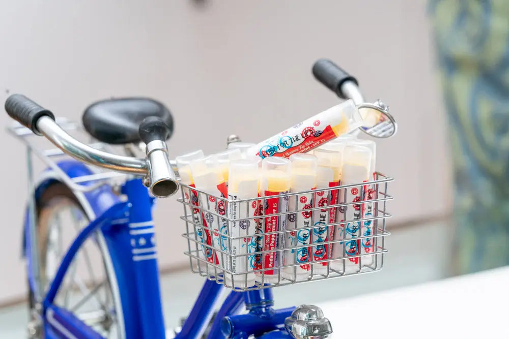Blue bicycle basket filled with Pedaling Peppermint lip balm tubes