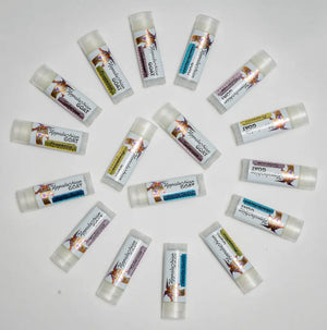 Multiple lip balm tubes with labels indicating flavors like Prosecco and Vanilla Swirl.