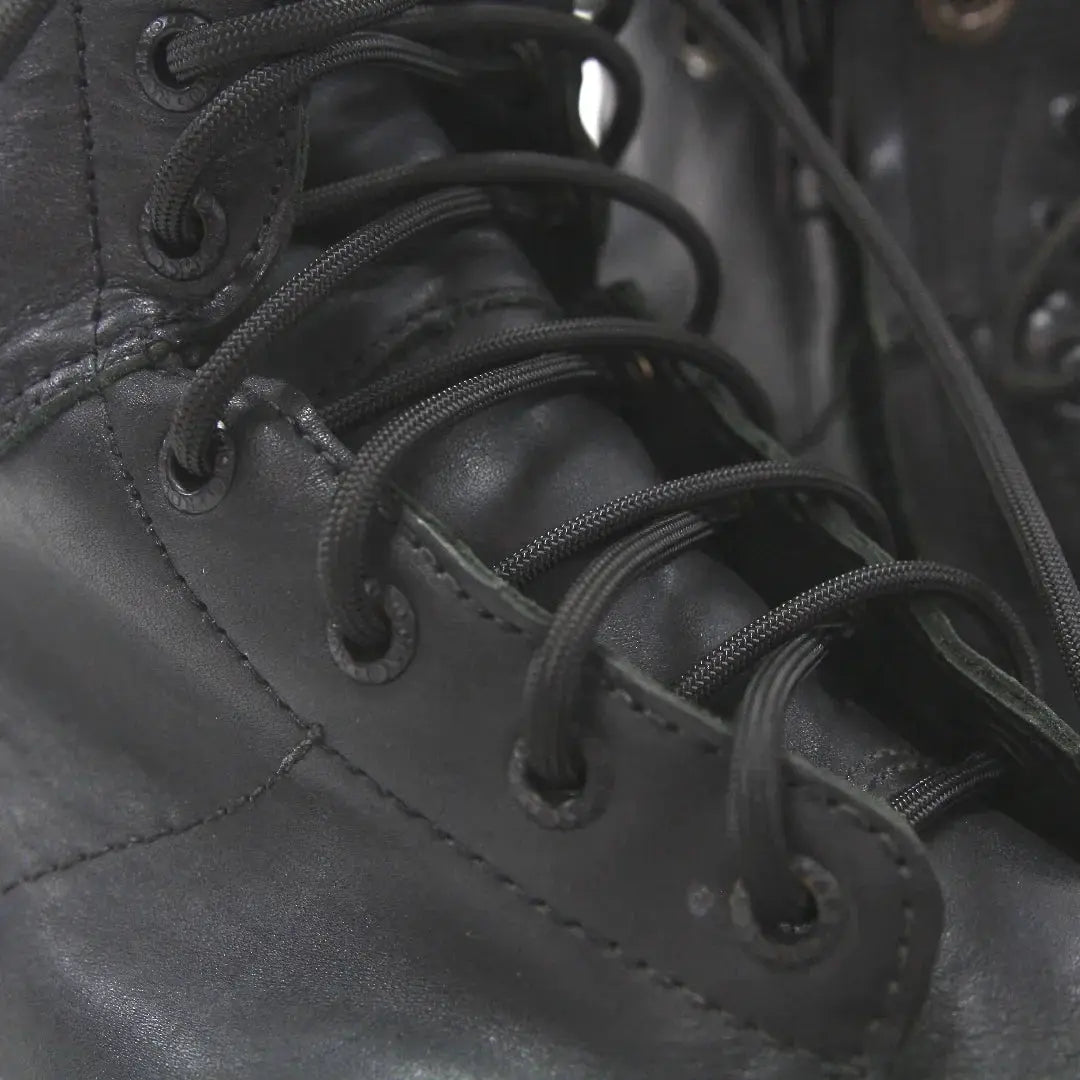 Black paracord boot laces threaded through eyelets on a black boot.