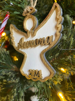 Personalized Angel Ornament 2024: Gold-edged wooden Christmas decoration with name, angel shape on tree.