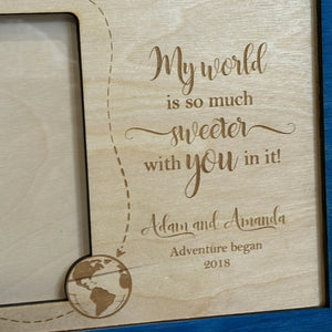 Personalized wooden frame with engraved quote \"My world is so much sweeter with you in it!\", names Adam and Amanda, and globe detail.