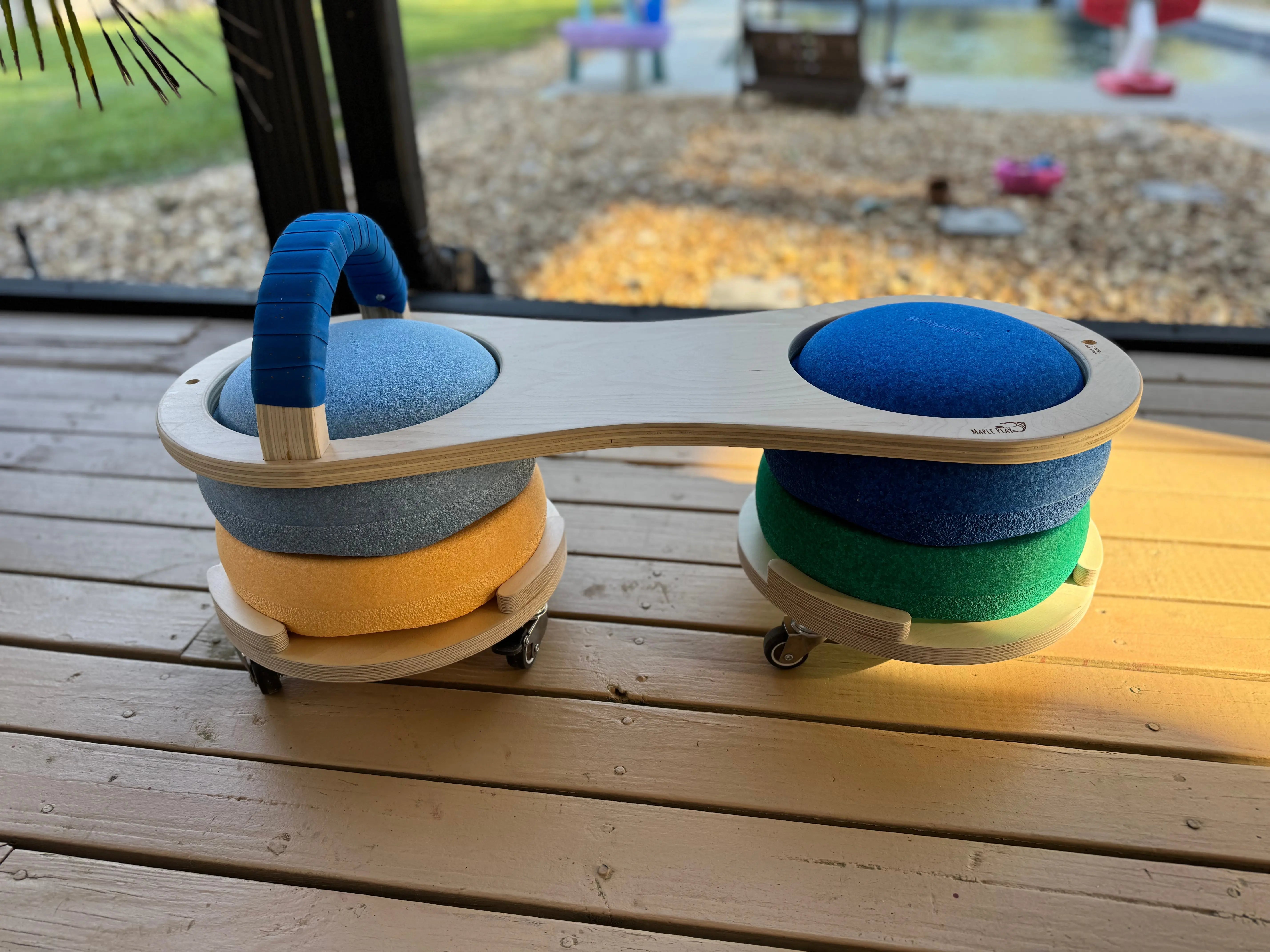 Wooden Scooter Board with blue and grey seating and colorful stacked bases.