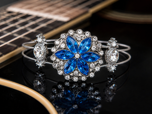 Bracelet with blue flower design and clear stones on a guitar