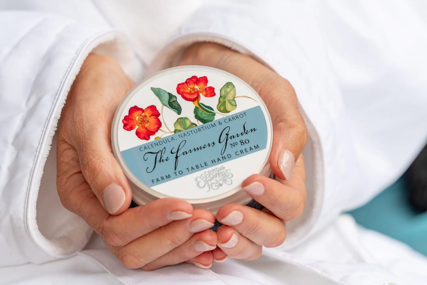 The Farmers Garden hand cream with calendula and nasturtium flowers on the label.