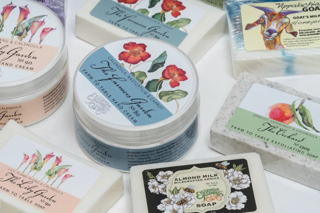 Collection of Essential Journeys hand creams and soaps with floral and fruit labels.