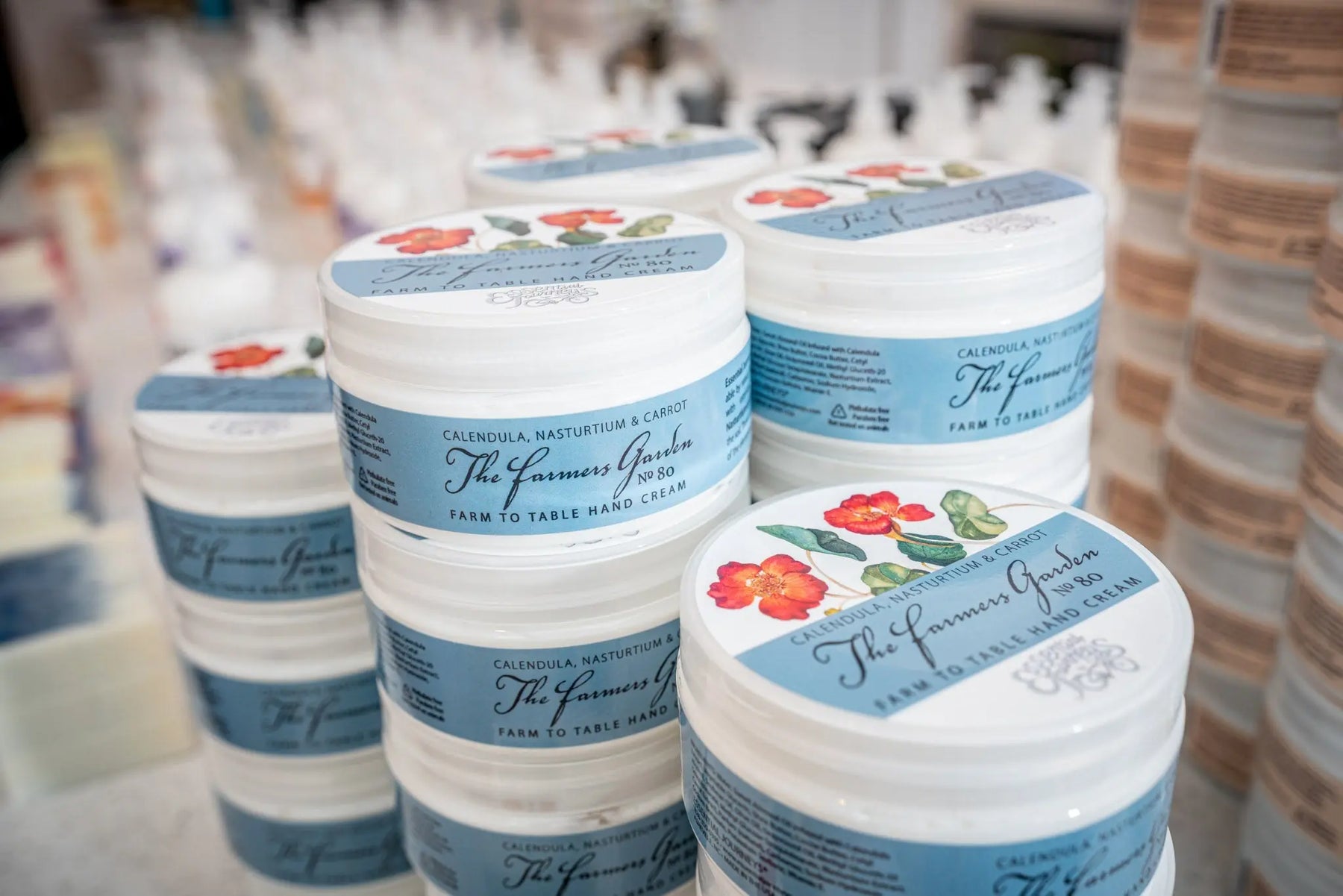 Jars of The Farmers Garden Farm to Table Hand Cream stacked on shelves.