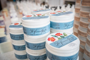 Jars of The Farmers Garden Farm to Table Hand Cream stacked on shelves.