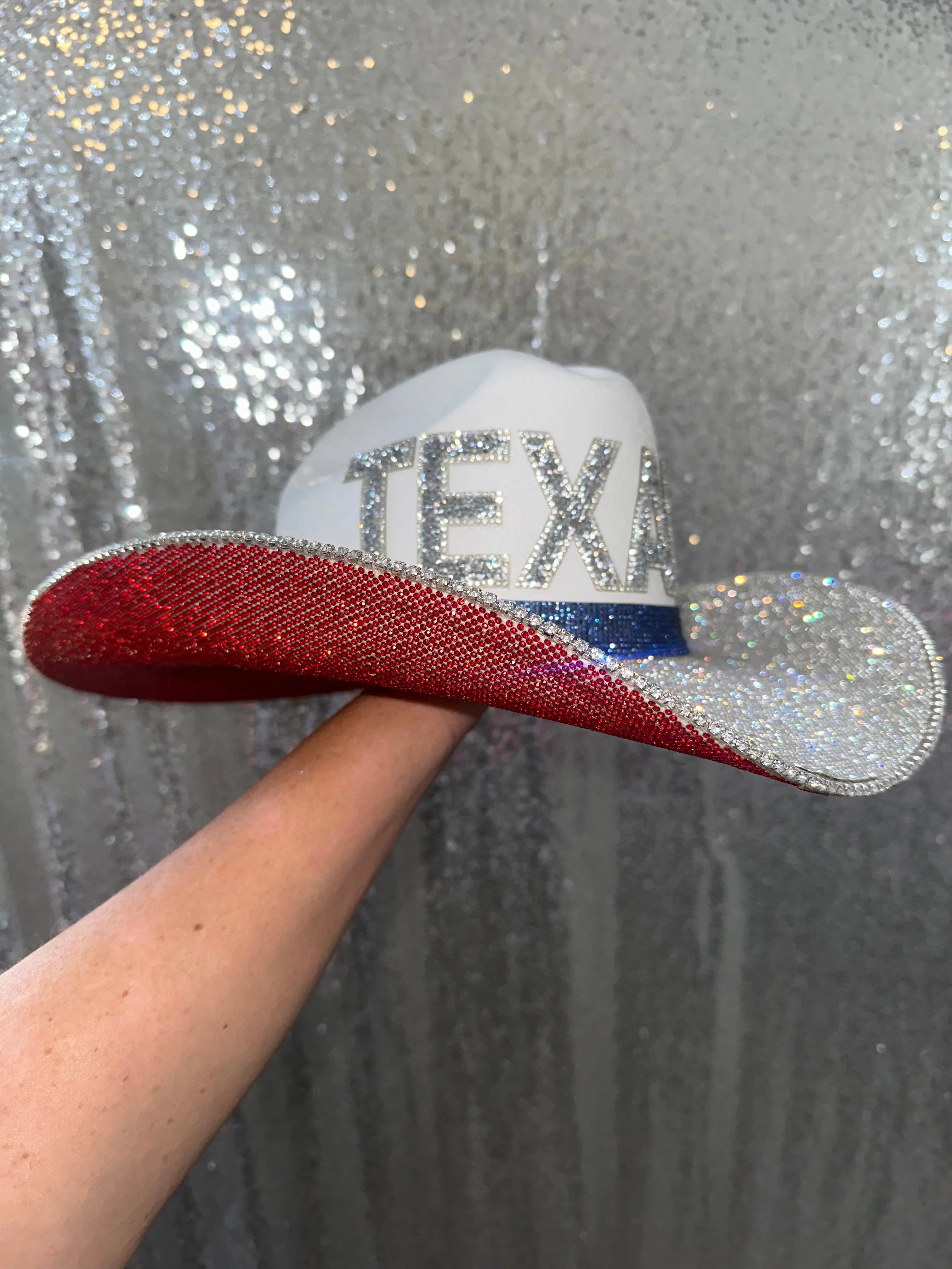 White cowboy hat with red, white, and blue rhinestones and TEXANS text.