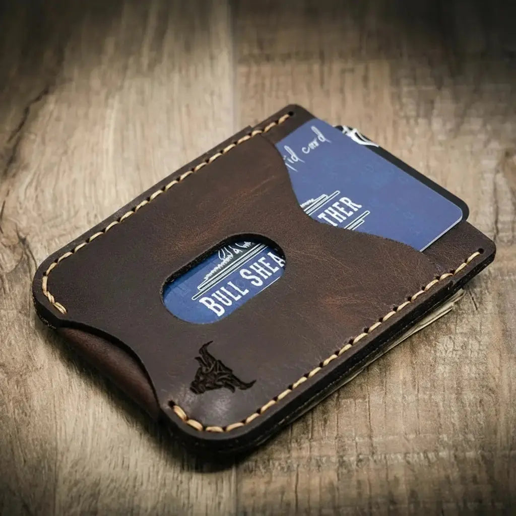 Dark brown leather money clip wallet with blue cards and a bull logo