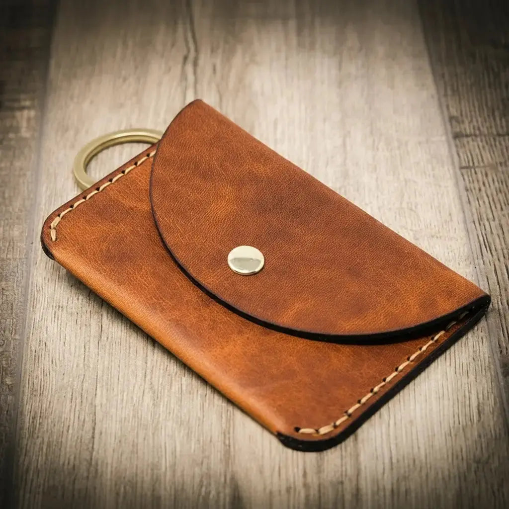 Brown leather keychain wallet with snap closure and brass ring.