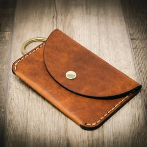 Brown leather keychain wallet with snap closure and brass ring.