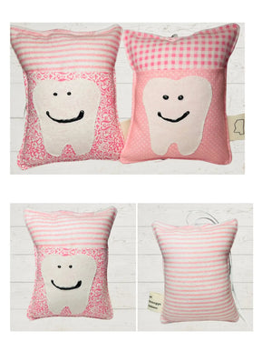Pink and white cotton tooth fairy pillows with a smiling tooth applique and a small pocket for a tooth.