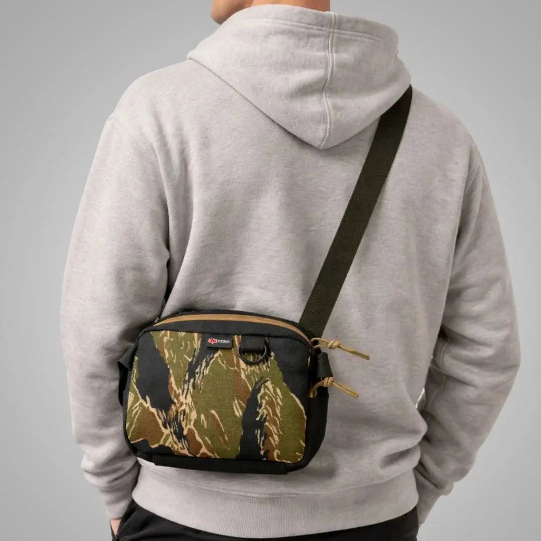 Man wearing grey hoodie with camouflage fanny pack crossbody bag