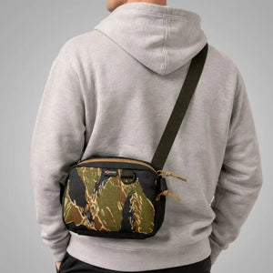 Man wearing grey hoodie with camouflage fanny pack crossbody bag