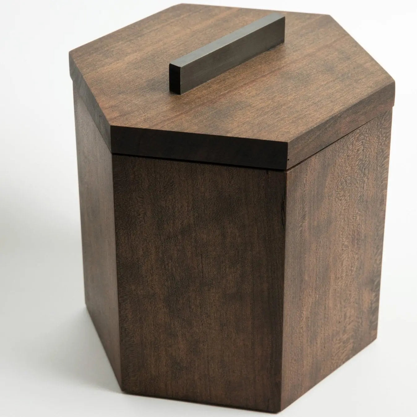 Hexagonal wooden ice bucket made from cherry wood with a blackened steel handle on a white background.