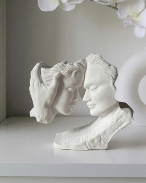 Modern couple sculpture with two faces and a supporting hand