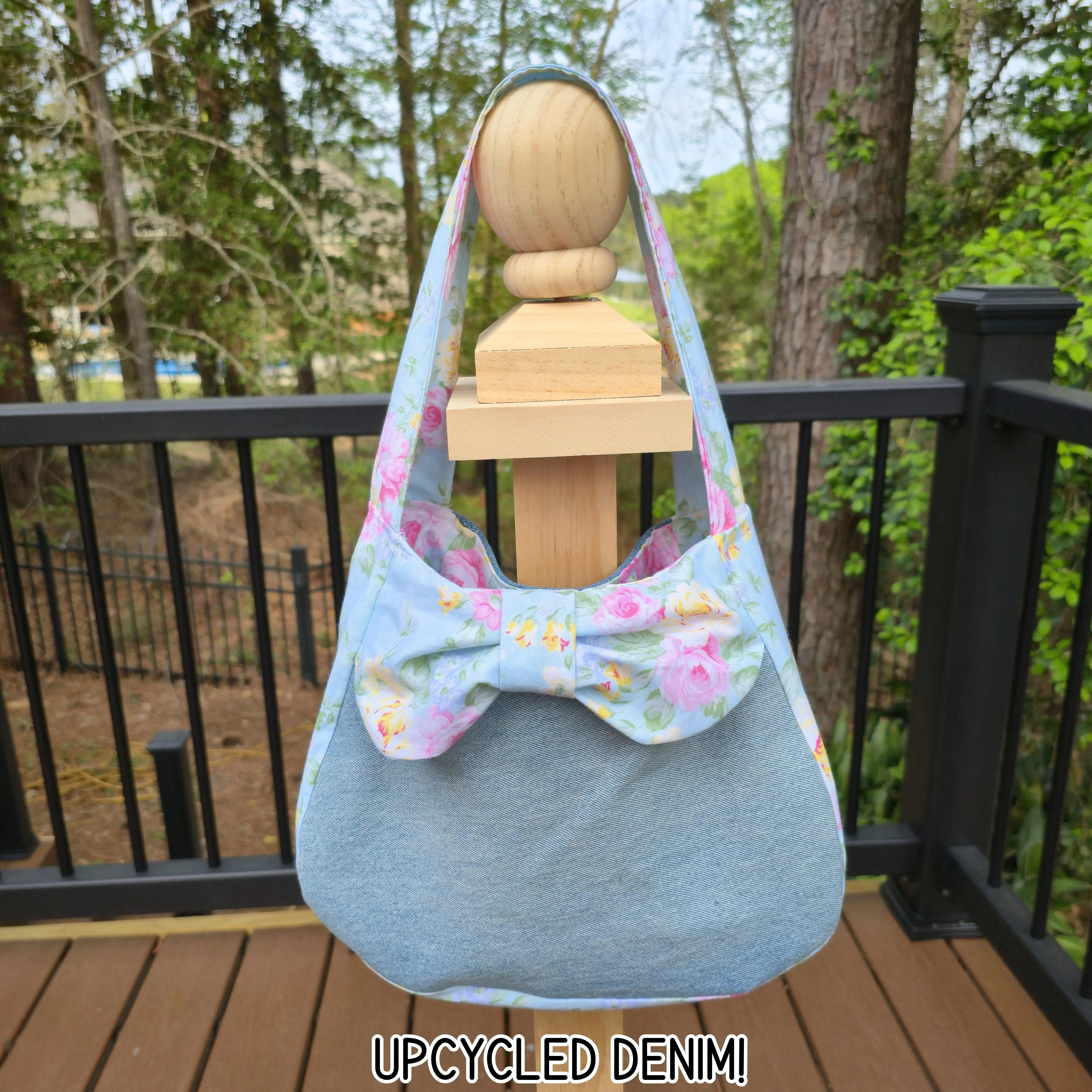 Upcycled denim shoulder bag with floral bow detail and denim strap.