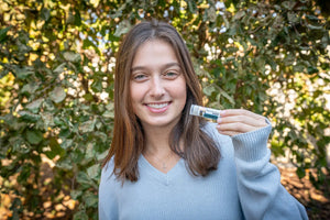Woman holding a tube of Appalachian Goat Vanilla Swirl Luxury Lip Butter.