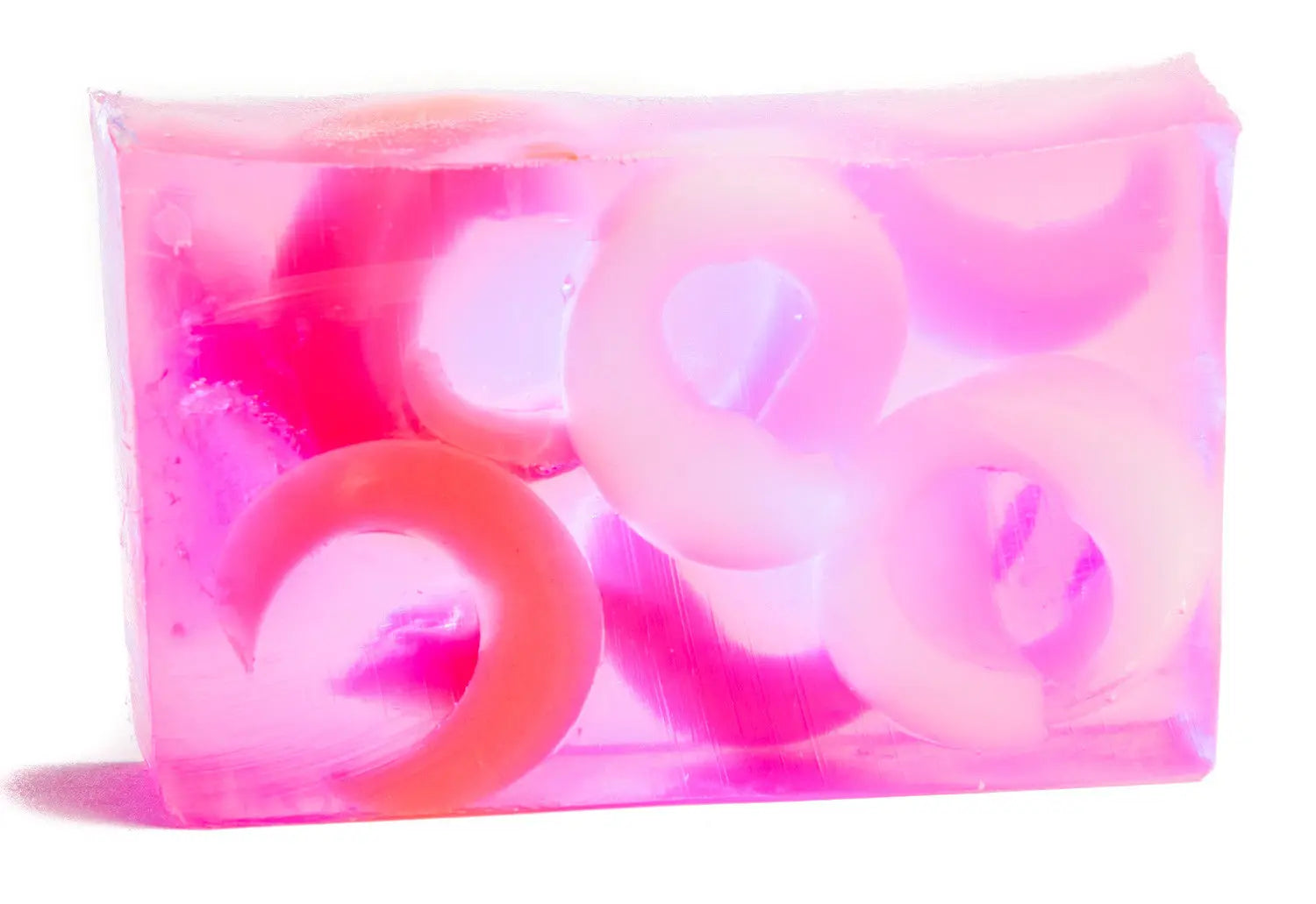 Pink and clear soap bar with pink and white ring-shaped embeds, on a white background.