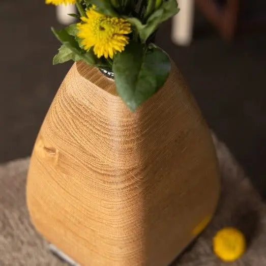 White Oak Wooden Vase with Yellow Flowers and a Bronze Base on a Grey Table