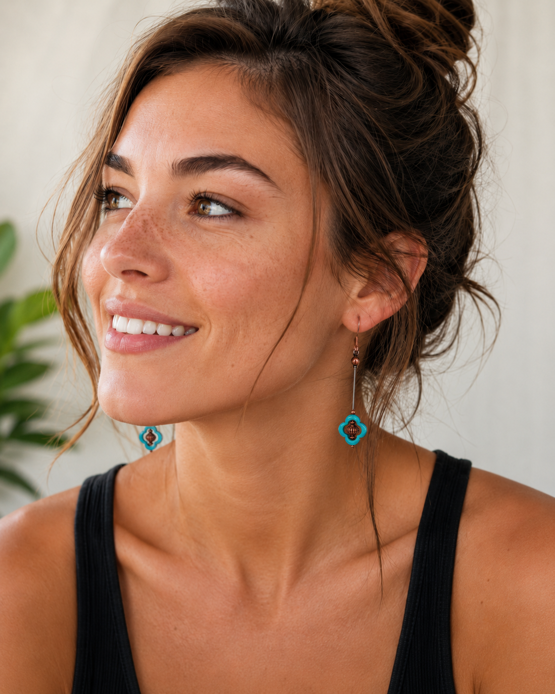 Woman wearing turquoise earrings with a neutral background