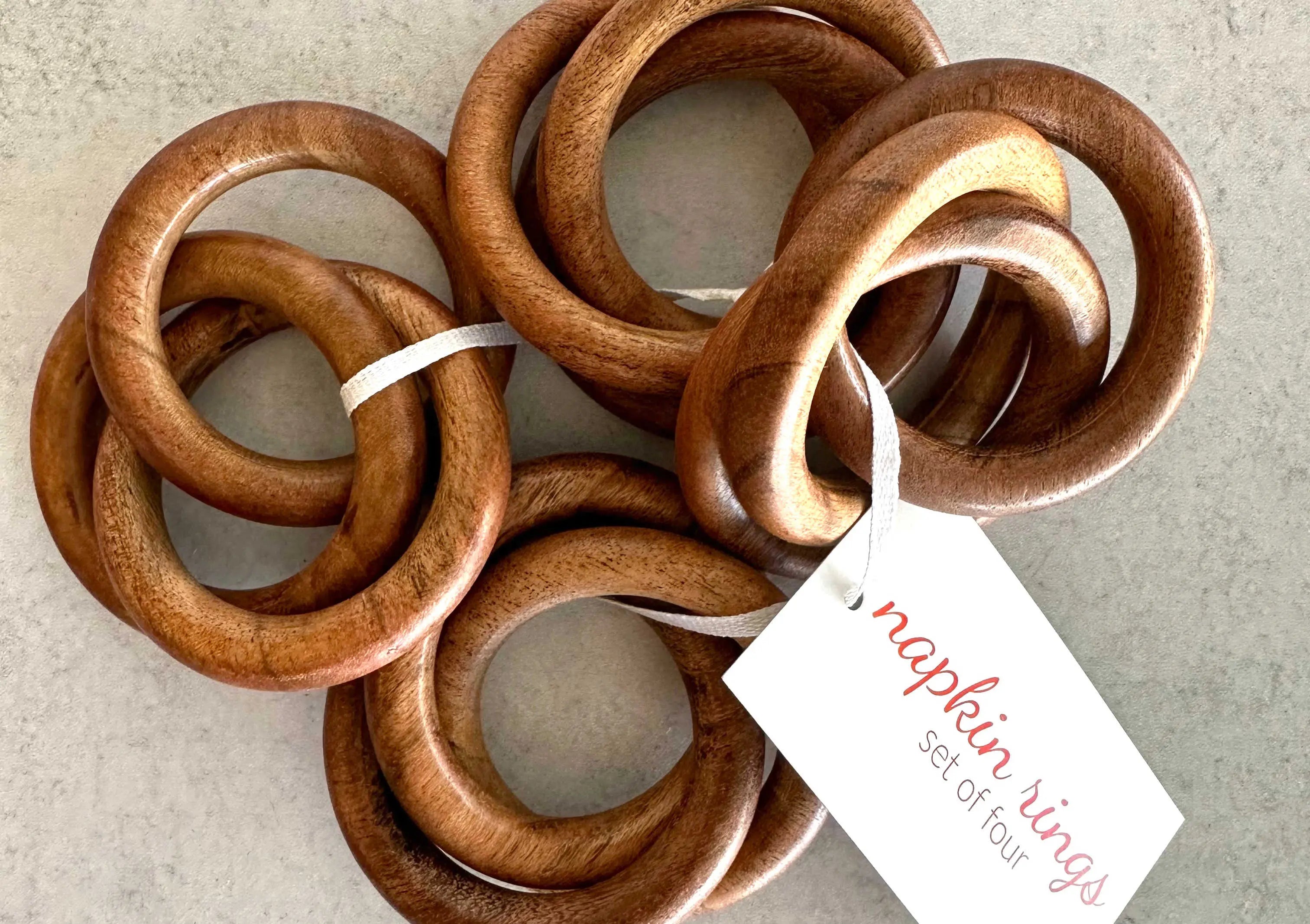 Wooden bangle napkin rings, set of four, with visible natural grain.