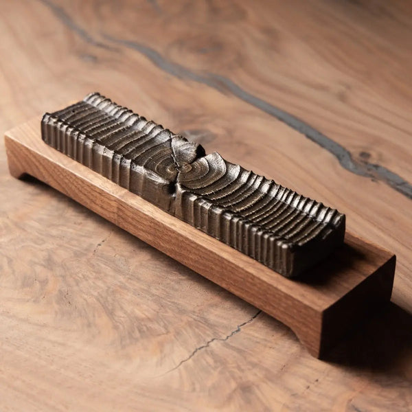 Wooden incense holder made of cast bronze and urban wood on a wooden stand, showcasing unique wood grain.