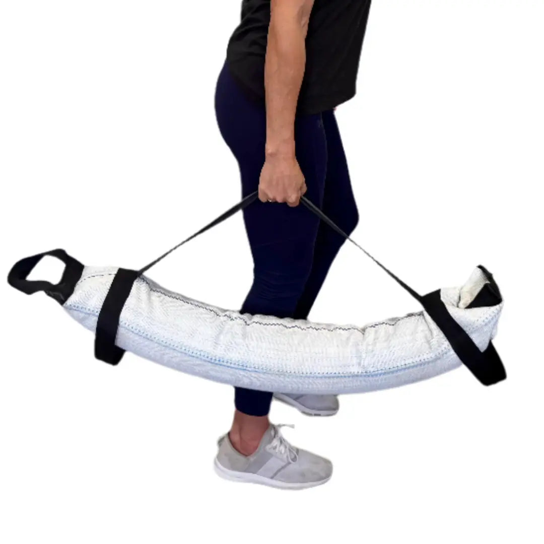 Person carrying a white workout battle bag with black handles and straps.