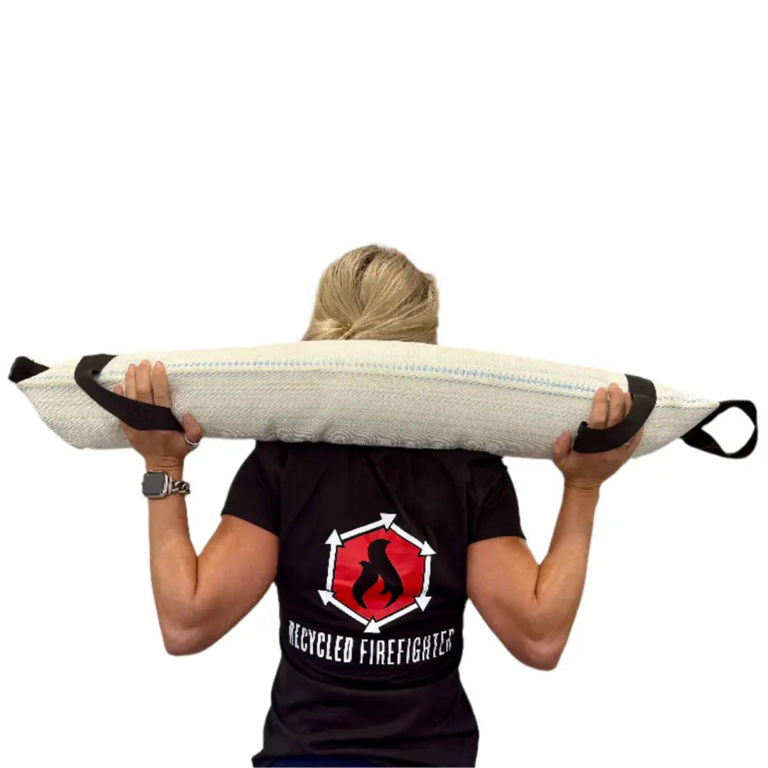 Person carrying a workout battle bag over shoulders, Recycled Firefighter logo visible on shirt.
