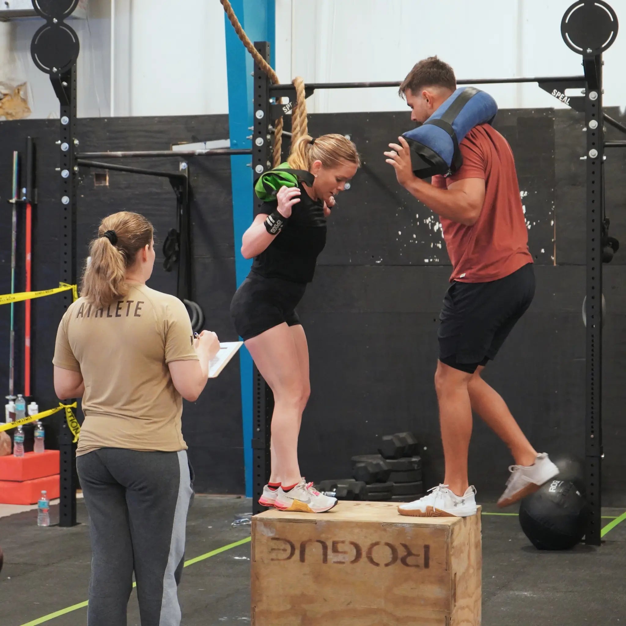 Workout battle bag on a wooden box with people exercising at a gym