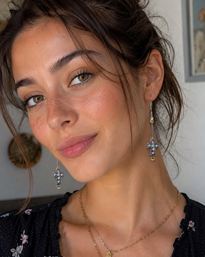 Close-up of a woman wearing earrings and a necklace indoors.