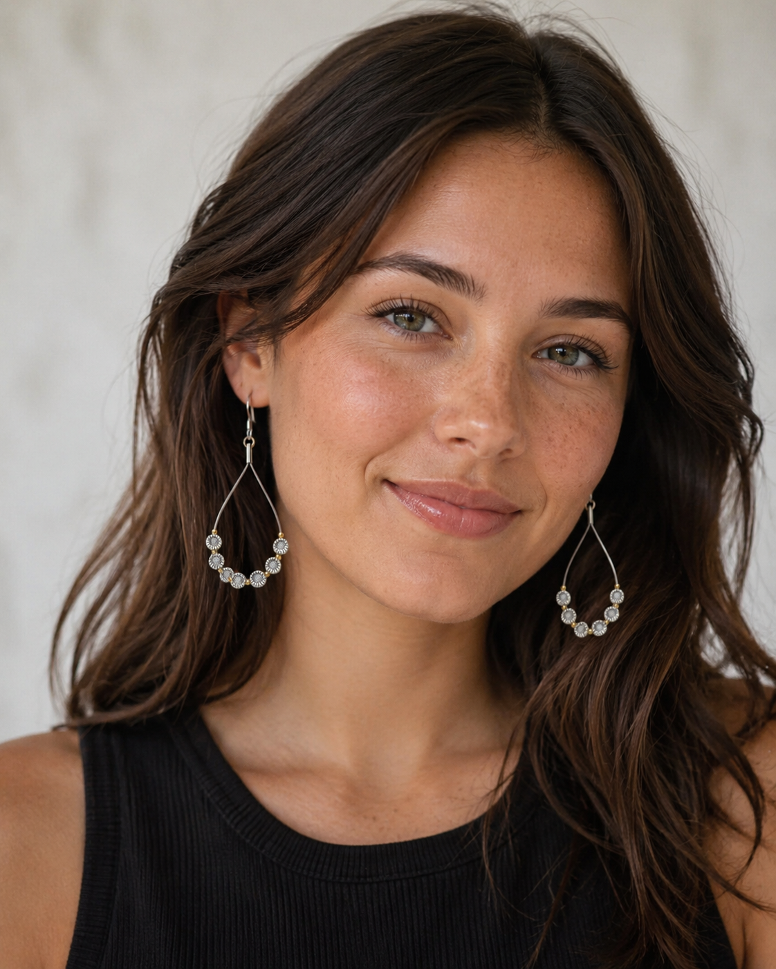 Woman wearing pearl earrings against a neutral background