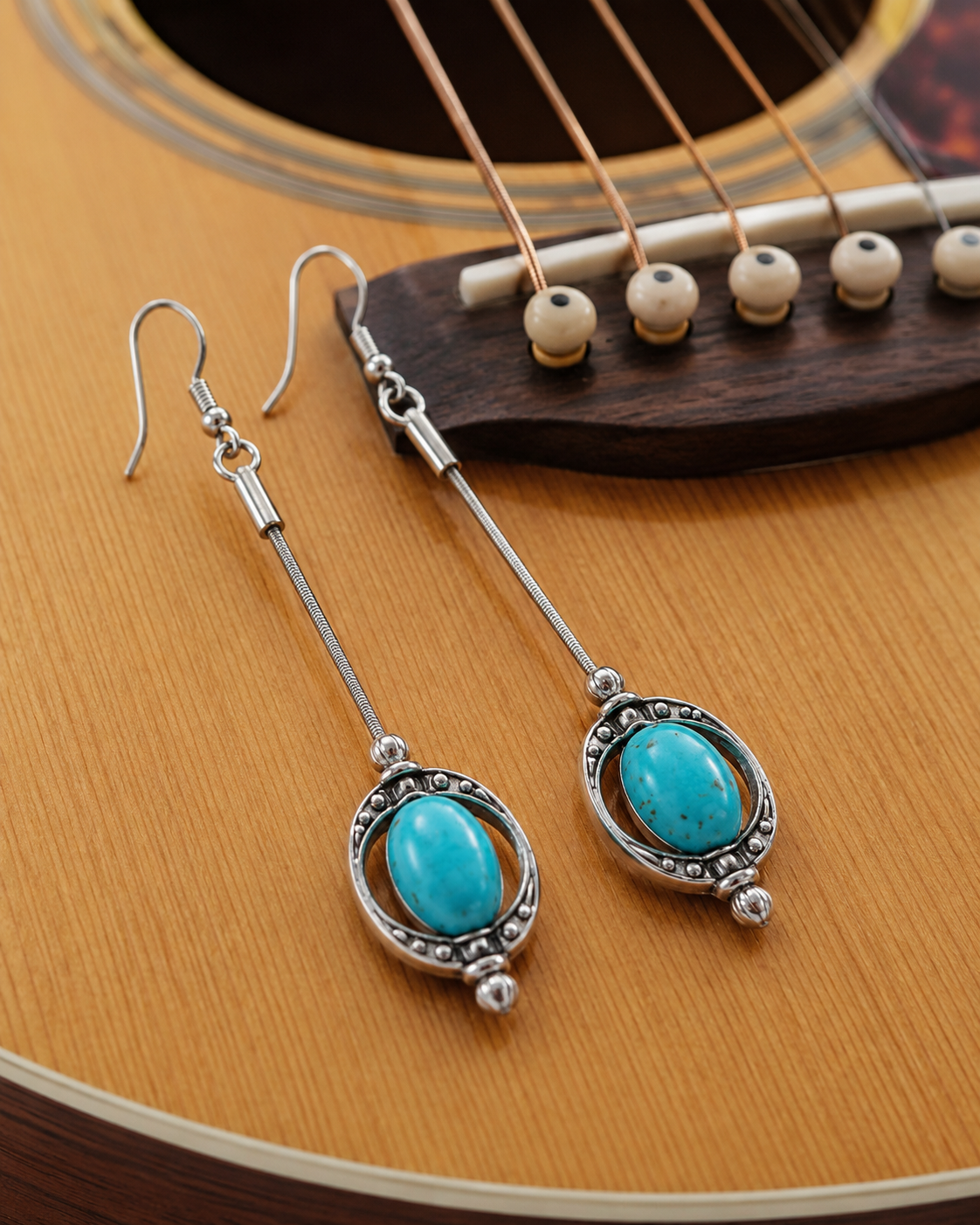 Turquoise earrings on a guitar