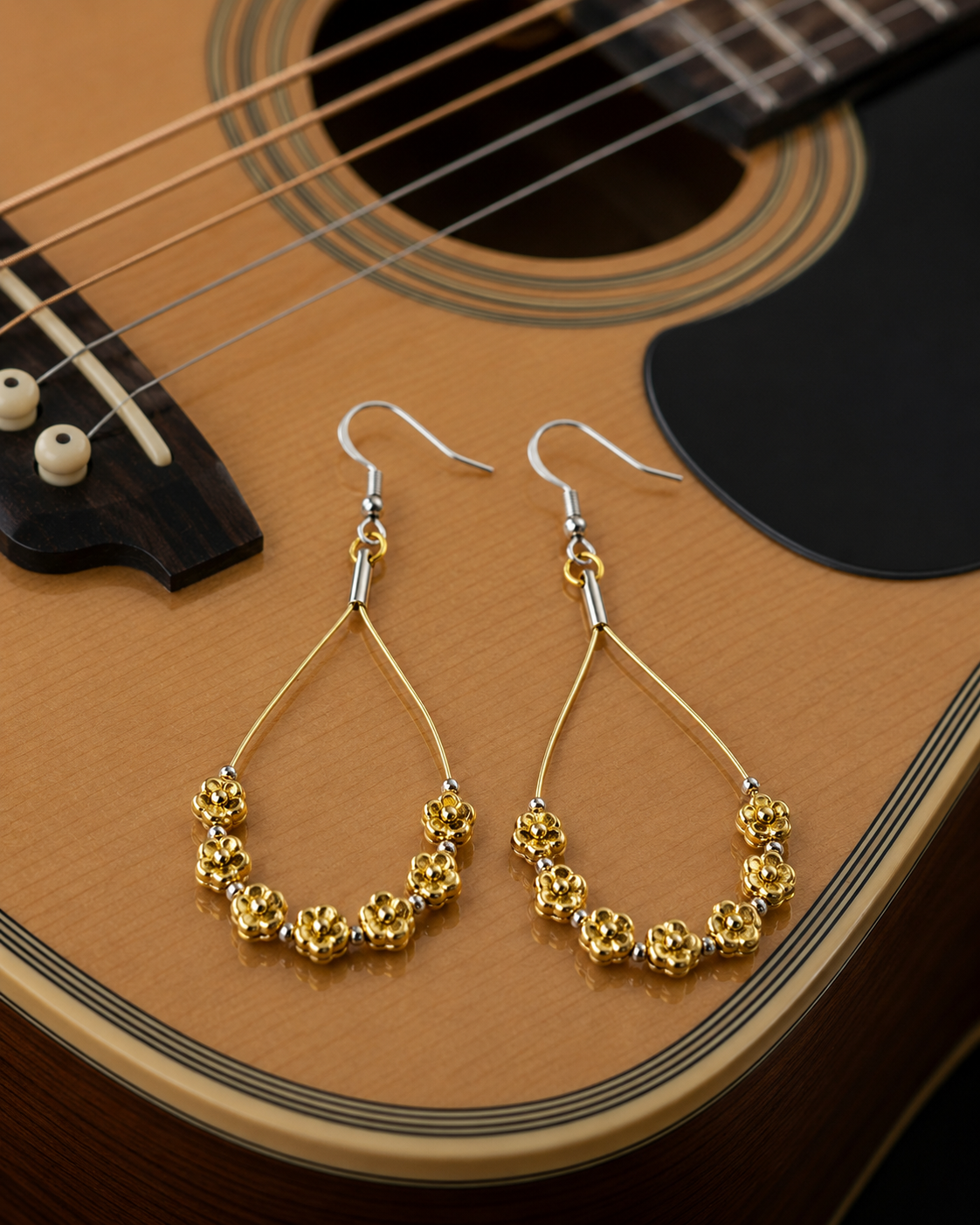 Gold hoop earrings on an acoustic guitar