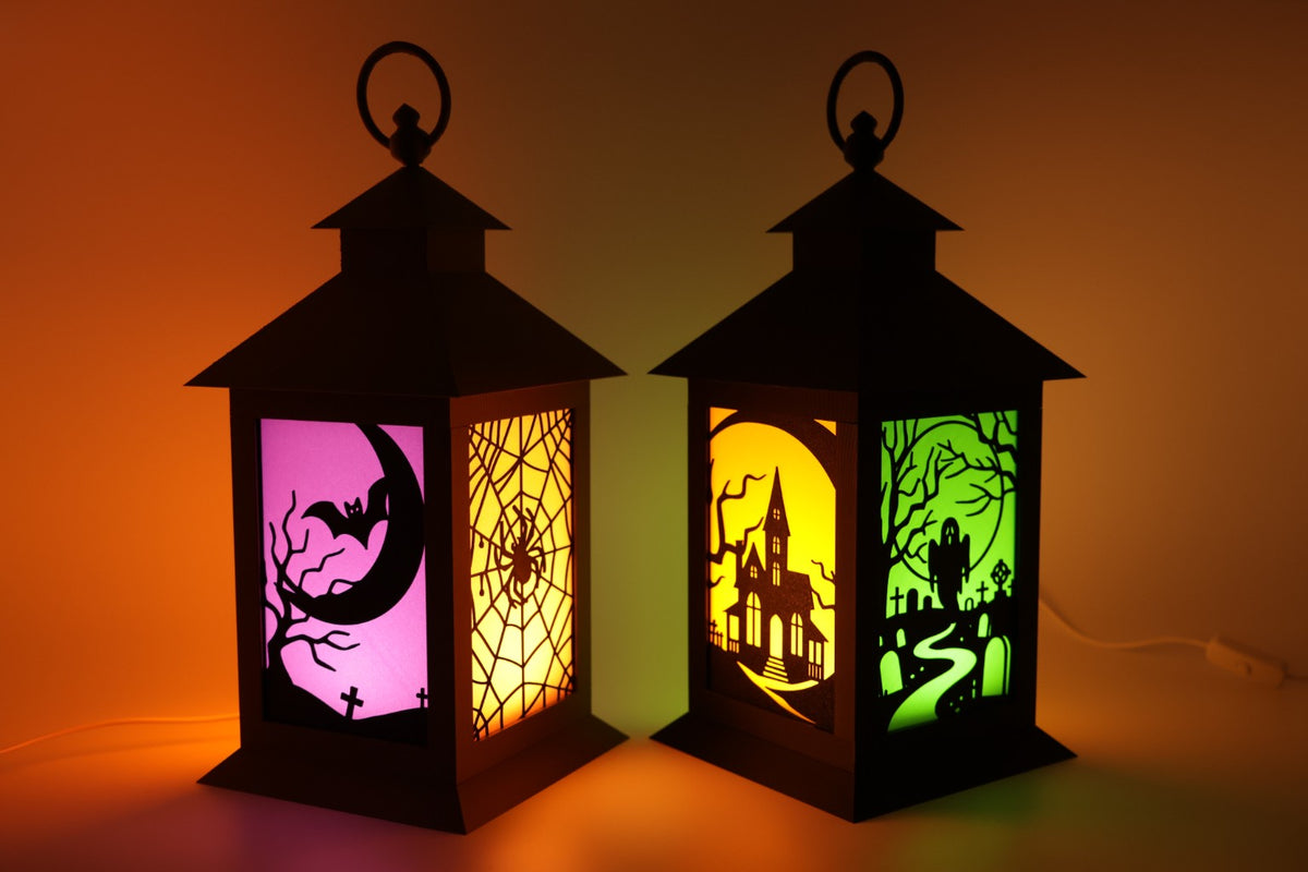 Set of two Halloween LED lanterns glowing with colorful spooky scenes