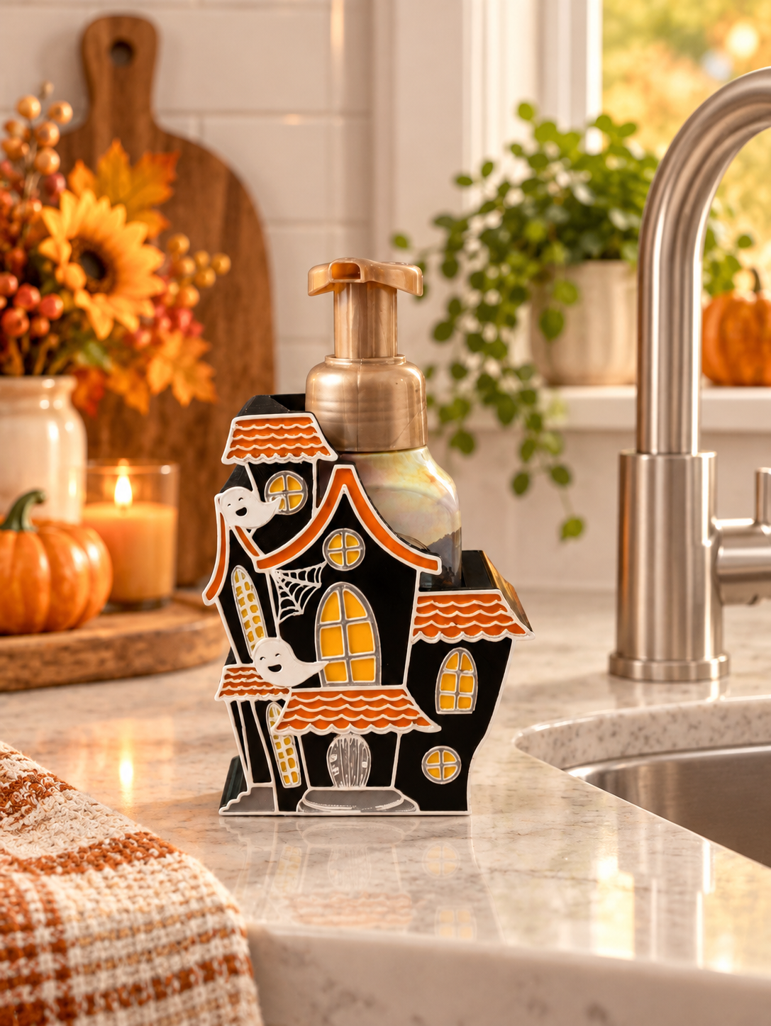 Haunted house Halloween soap dispenser holder styled beside a kitchen sink