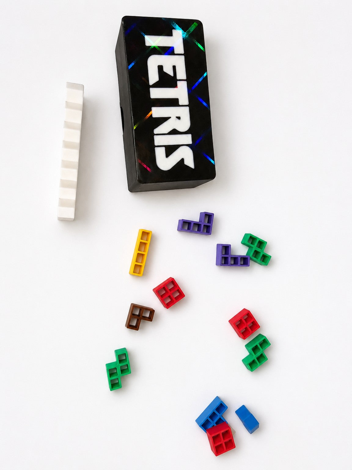 Mini Tetris style travel puzzle game pieces arranged on a white table