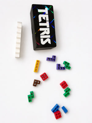 Mini Tetris style travel puzzle game pieces arranged on a white table