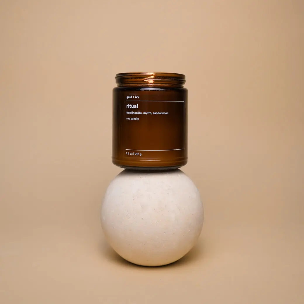 Brown glass soy candle labeled "Ritual" by gold + ivy