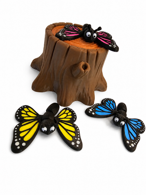 Angled product photo of The Tween Space butterfly playset with pink butterfly on tree stump and yellow and blue butterflies nearby