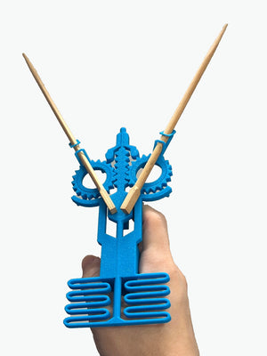 Blue crossbow chopstick holder by The Tween Space shown with chopsticks for demonstration; chopsticks not included.