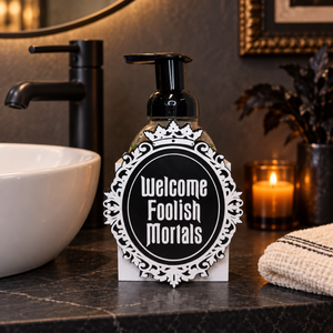 Welcome Foolish Mortals Halloween soap dispenser beside a bathroom sink